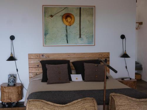 a bedroom with a bed with two lights on the wall at Casas do Amarelo in São Mateus