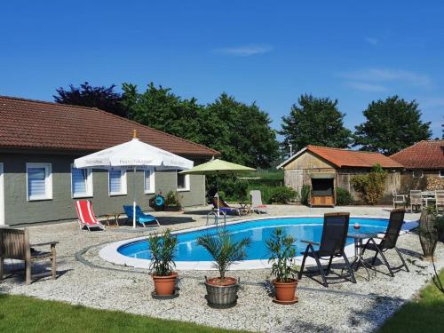 uma piscina num quintal com cadeiras e um guarda-sol em 07 Birkenhain em Parchtitz