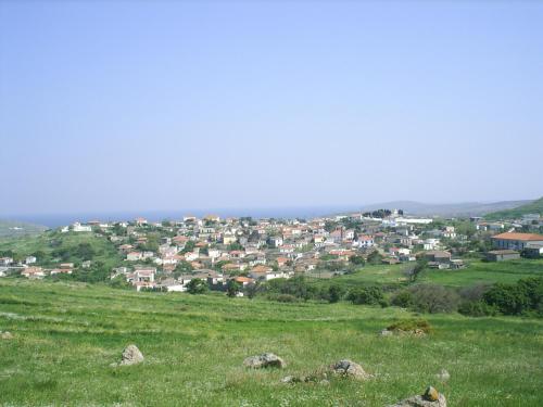 a green field with a town in the background at Old House Villa Moudros- Kaminia Lemnos Λήμνοs in Ayía Sofía