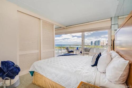 a bedroom with a large bed and a balcony at Ilikai #1743 Panoramic views on Waikiki Beach in Honolulu