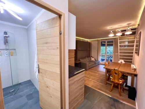 a kitchen and dining room with a sliding door leading into a room with a table at La Baita Limone Riserva Bianca Ski-in Ski-out Seggiovia Morel 1 in Limone Piemonte