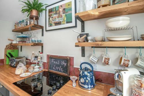 a kitchen with wooden shelves and a counter top at The Loveshack Lodge Balquhidder in Balquhidder