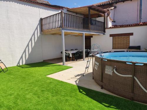 a backyard with a swimming pool and green grass at CASA RURAL VEGASAN in Santa Colomba de la Vega