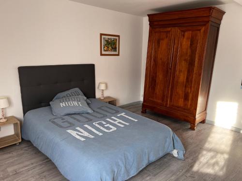 Schlafzimmer mit einem Bett und einem Holzschrank in der Unterkunft F2 gatinais in Pithiviers