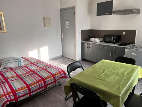 Schlafzimmer mit einem Bett, einem Tisch und Stühlen in der Unterkunft F2 gatinais in Pithiviers