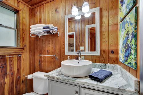 a bathroom with a sink and a toilet and a mirror at Lake Haven Cottage On Lake Hamilton in Hot Springs