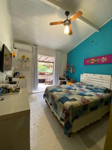 - une chambre avec un lit et un ventilateur de plafond dans l'établissement Casa Aconchego - Arraial D Ajuda- Bahia, à Arraial d'Ajuda