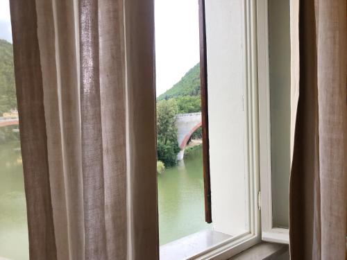 a window with a view of a bridge over a river at La Finestra sul Fiume in Fossombrone