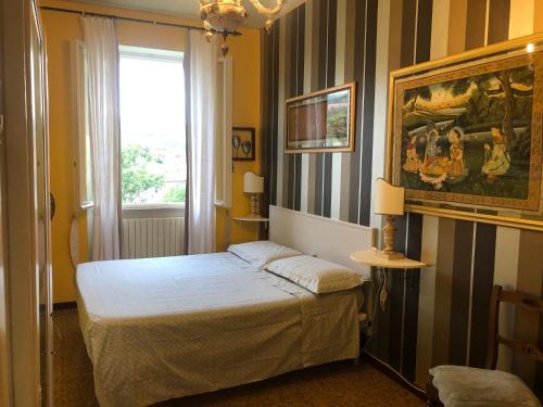 a bedroom with a bed and a painting on the wall at La Finestra sul Fiume in Fossombrone