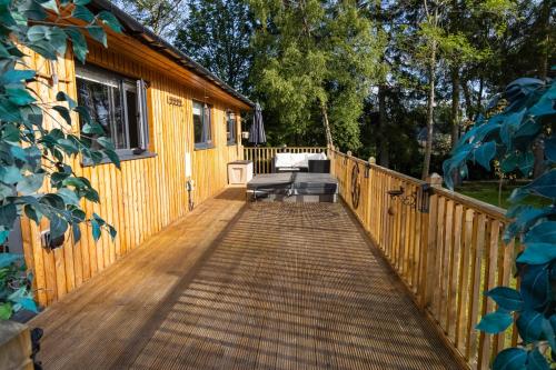 a wooden walkway leading to a cabin with a porch at Settlers Lodge in Otterburn