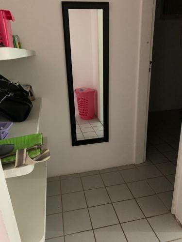 a bathroom with a mirror and a pink basket at casa de 4 quartos perto do Forte Orange Itamaracá in Itamaracá