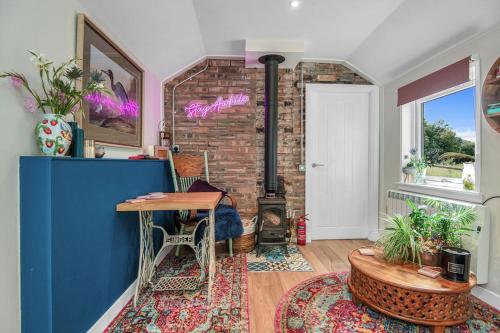 a room with a table and a brick wall at The Loveshack Lodge Balquhidder in Balquhidder
