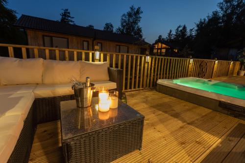 a patio with a couch and a table next to a pool at Settlers Lodge in Otterburn