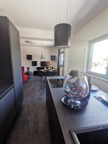 a kitchen with a bowl on a counter and a living room at Oasis in the city near Amfiteatar,free parking and free Wi-Fi in Pula