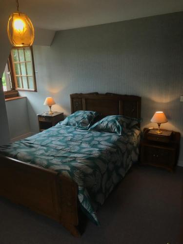a bedroom with a bed and two night stands with lamps at La Résidence de Marie in Brommat
