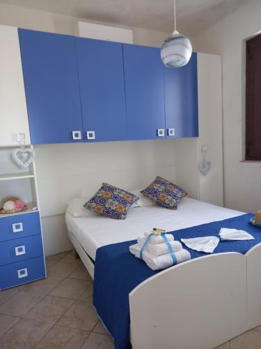 - une chambre avec 2 lits avec des armoires bleues et un tiroir bleu dans l'établissement Villa Serena, à Granelli