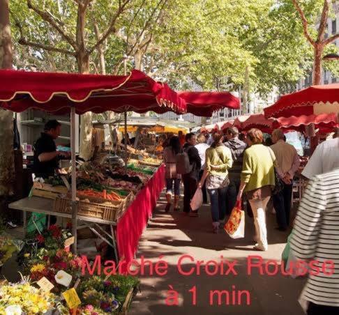 a group of people walking around an outdoor market at La petite Maison dans la Croix Rousse in Lyon