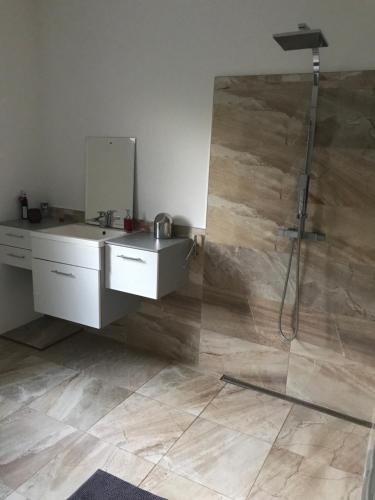 a bathroom with a sink and a shower with a mirror at Izba v čarovnom dome in Svätý Jur