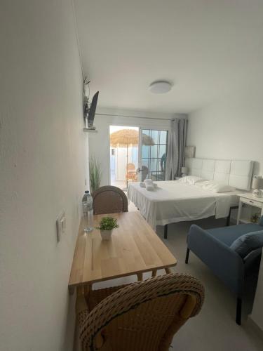 ein Wohnzimmer mit einem Tisch und einem Bett in der Unterkunft Apartamentos Elena in Lajares