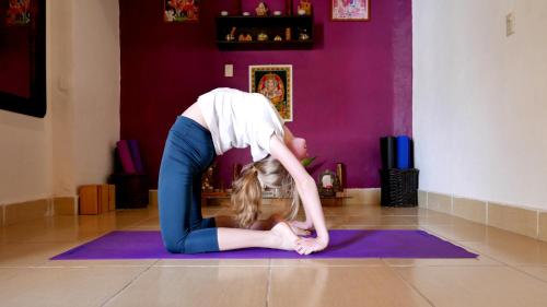a woman doing a yoga pose on a yoga mat at Ganesha Hotel in San Cristóbal de Las Casas