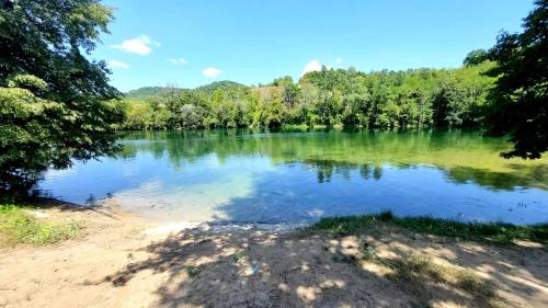 Vue sur un lac avec des arbres en arrière-plan dans l'établissement Stan na dan Novi Grad, à Bosanski Novi