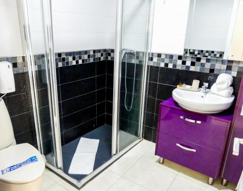 Apartamentos Guadalupe Gran Canaria Puerto Rico في موجان: حمام مع حوض أرجواني ودش