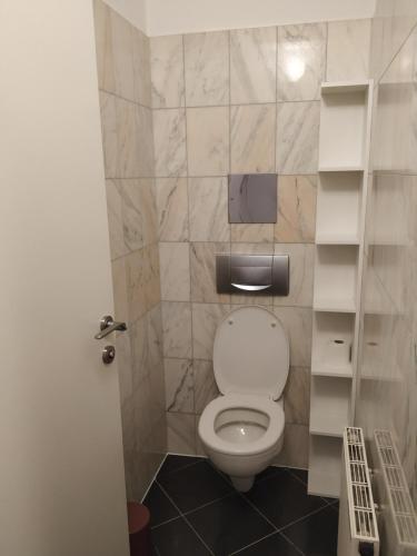 y baño con aseo blanco en una cabina. en CozyNite Premium Apartment Ottakring, en Viena