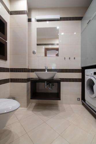 a bathroom with a sink and a washing machine at Apartament Andy Wisła in Wisła