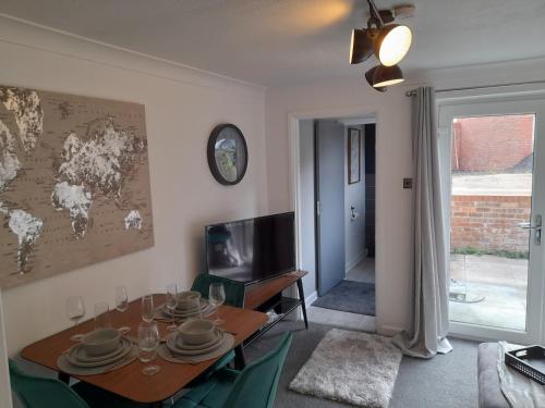 a dining room with a table and a tv at 93 Newtown Road in Great Malvern