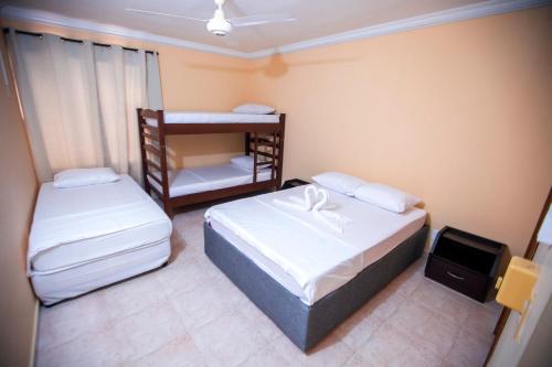 niewielka sypialnia z 2 łóżkami i telewizorem w obiekcie Hostal Cartagonova - Habitaciones privadas y amplias cerca a zonas turísticas w mieście Cartagena de Indias