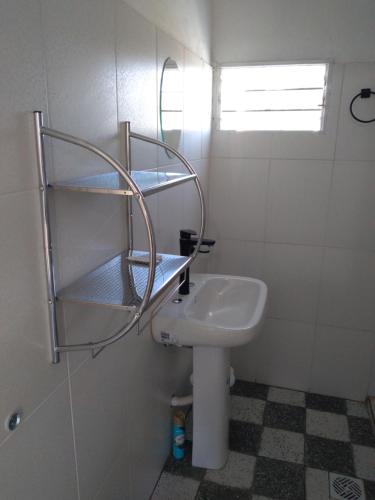 a bathroom with a sink and a toilet with shelves at Cuesta de san miguel in Chilecito