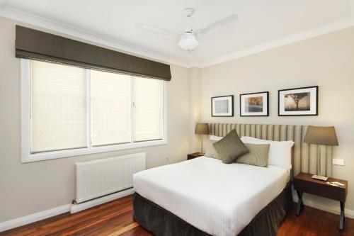 a bedroom with a white bed and a window at Peppers Craigieburn Resort in Bowral