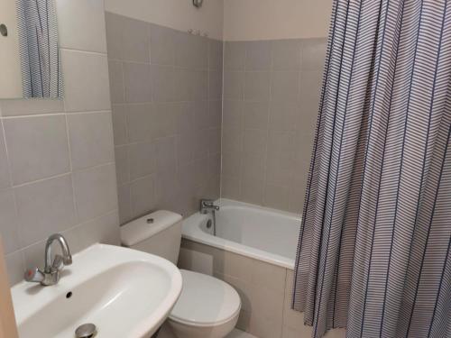 y baño con lavabo, aseo y cortina de ducha. en T1 L'Orchidée - 10min à pied de la gare, en Montpellier