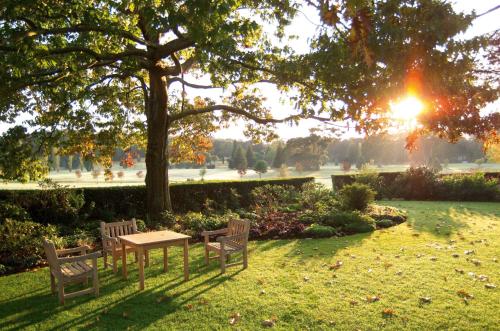a picnic table and benches under a tree in a park at Peppers Craigieburn Resort in Bowral