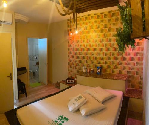 a room with a table and a brick wall at Hotel & Motel ap Aparecida de Goiânia in Aparecida de Goiania