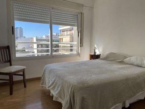 um quarto com uma cama e uma grande janela em Hermoso departamento sobre Cabildo y contrafrente em Buenos Aires