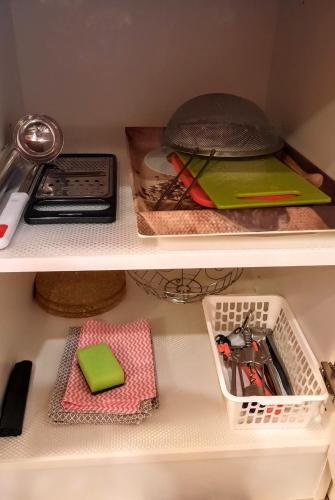 two shelves of a kitchen cabinet with some items at Apartmá Za kopcem in Boskovice