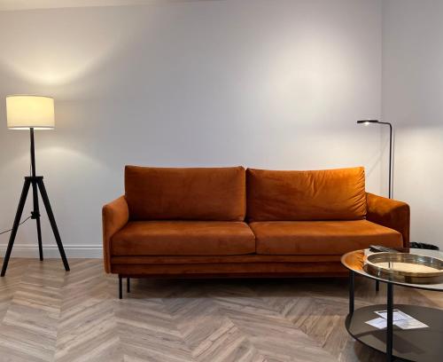 - un canapé brun dans le salon avec une table dans l'établissement Apartament Na Krzywym Kole, à Kazimierz Dolny