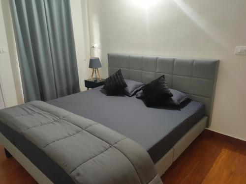 Una cama con almohadas negras en un dormitorio en Empra Exotica en Madikeri