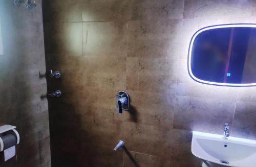 uma casa de banho com um lavatório e um espelho em Empra Exotica em Madikeri
