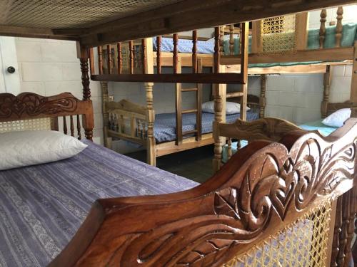 a bedroom with two bunk beds and a ladder at Nanda Parbat Hostal in San Rafael Cedros