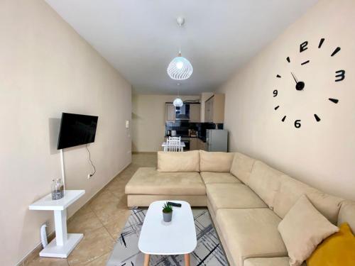 - un salon avec un canapé et un réveil sur le mur dans l'établissement Chlo apartment 2 Tirana, à Tirana