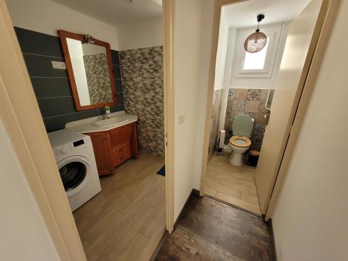 y baño con aseo, lavabo y lavadora. en Appartement indépendant proche Étang de l'Olivier, en Istres