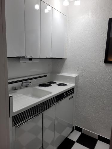 a white kitchen with a stove and a sink at Rocket Motel in Custer