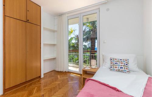 1 dormitorio con cama y ventana grande en 2 Bedroom Awesome Apartment In Icici en Ičići