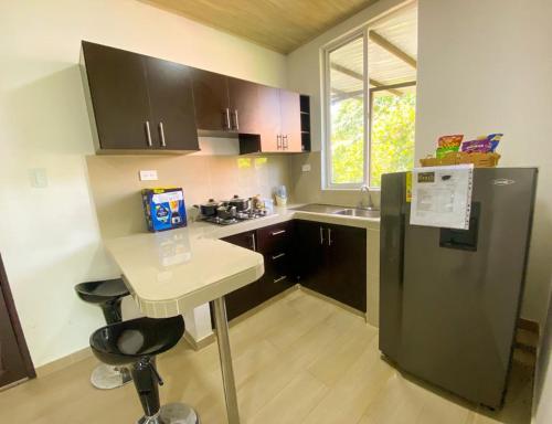 a kitchen with a black refrigerator and a table at Aparta-Hotel LENEMBERGER in Puerto Asís