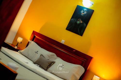 a bedroom with a bed with a wooden headboard at Prodiges Hôtel in Yaoundé