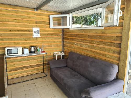 a leather couch sitting in a room with a microwave at Casa Vale Ecotainer in Lisbon