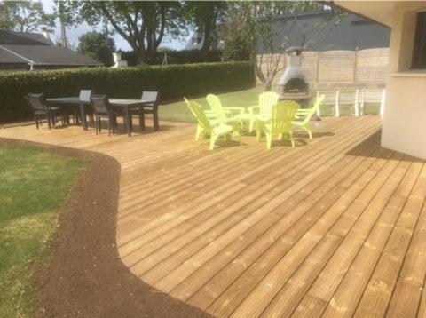 a group of chairs and tables on a deck at GITE DE L'ORCHIDÉE P M r in Locmaria-Grand-Champ