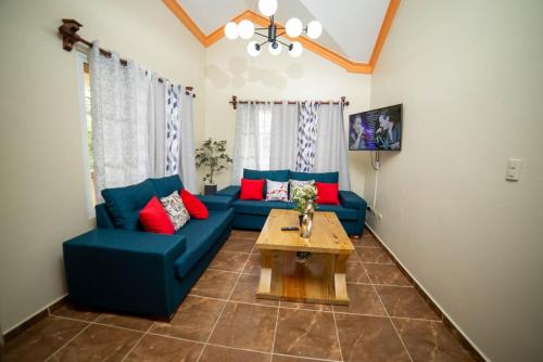uma sala de estar com sofás azuis e uma mesa de centro em Willy's house em Jarabacoa